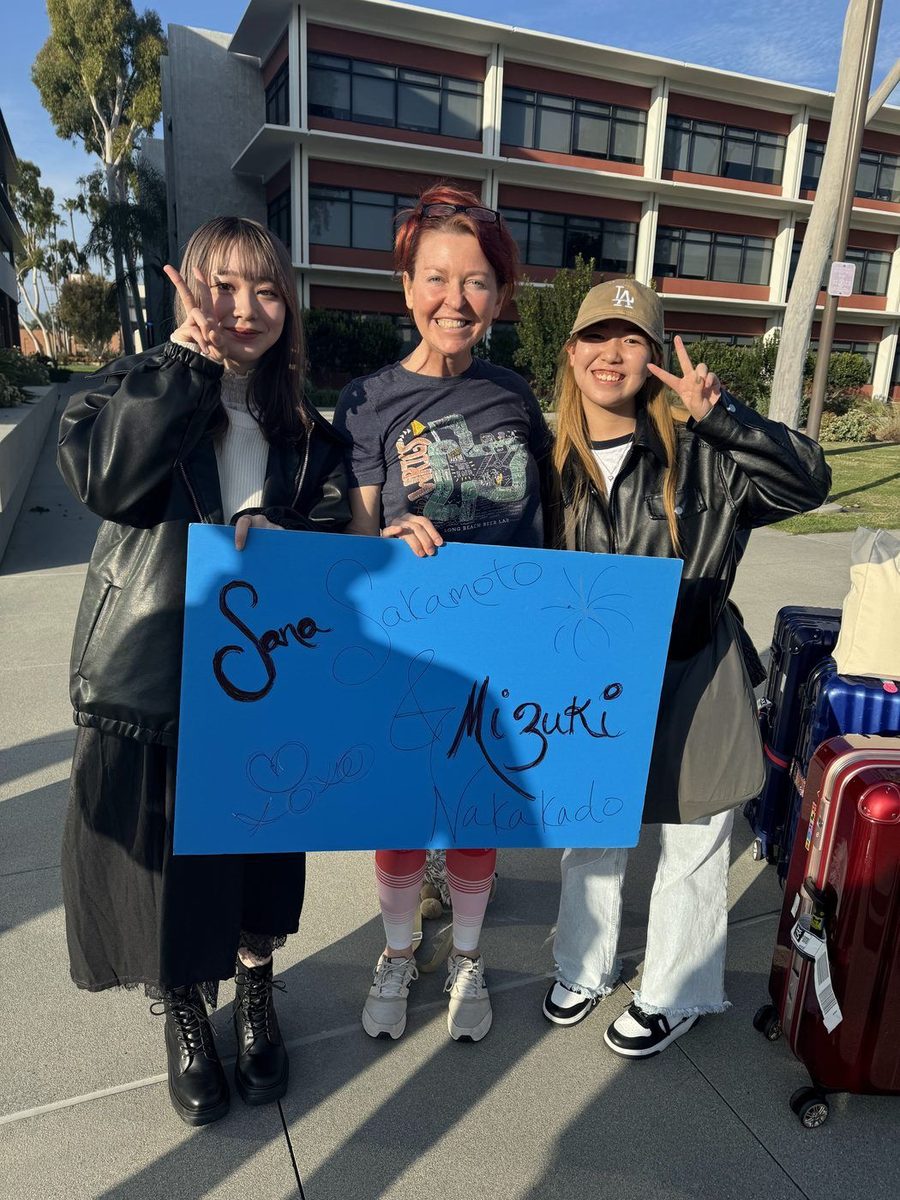 Host welcoming students Sane and Mizuki with a personalized sign