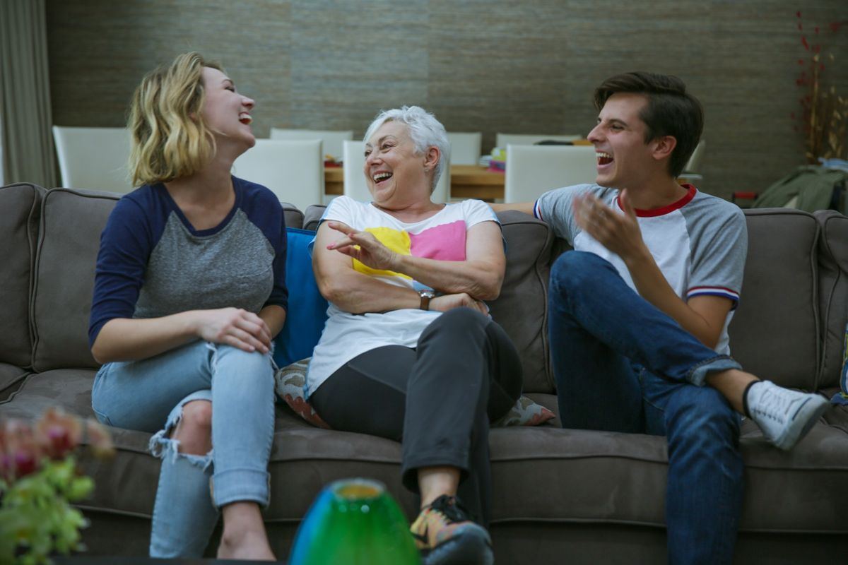 Host family laughing with students on couch
